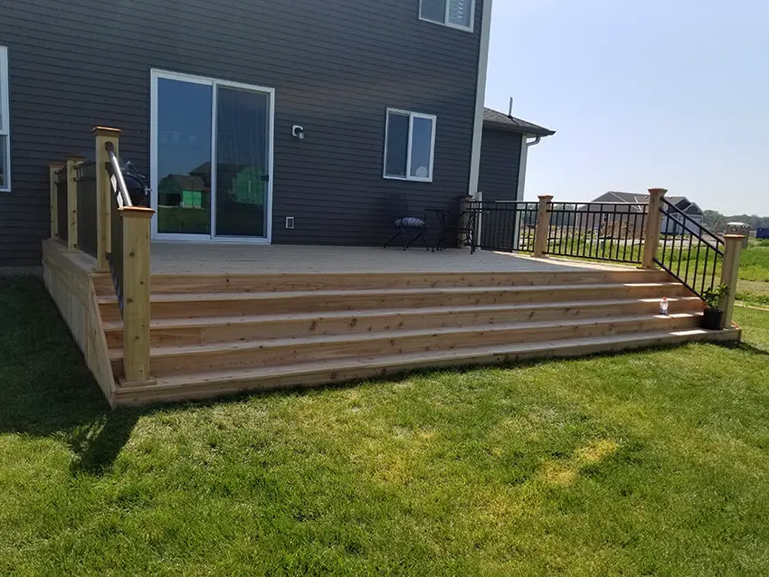 Cedar deck beside a home with mature trees